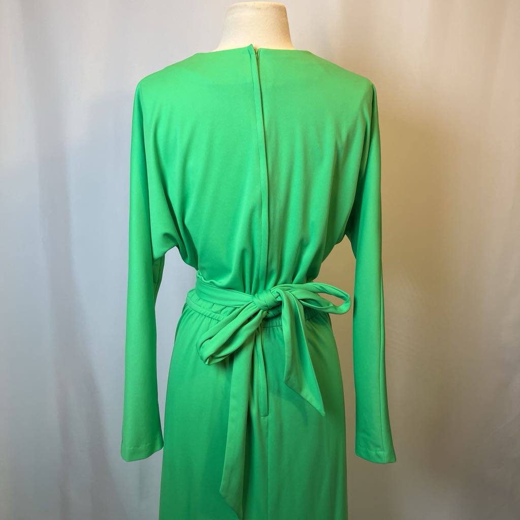Green dress on a mannequin against a plain background
