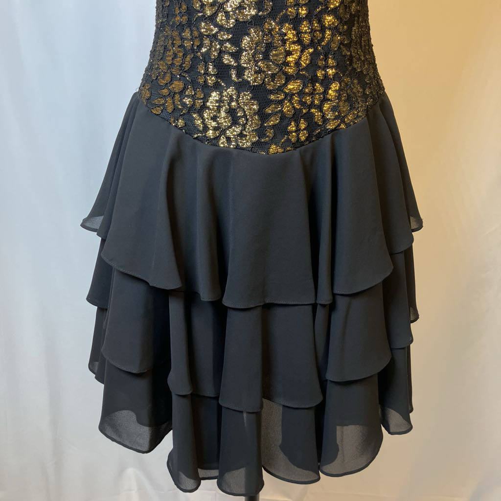 Black layered skirt with gold sequin top on a plain background