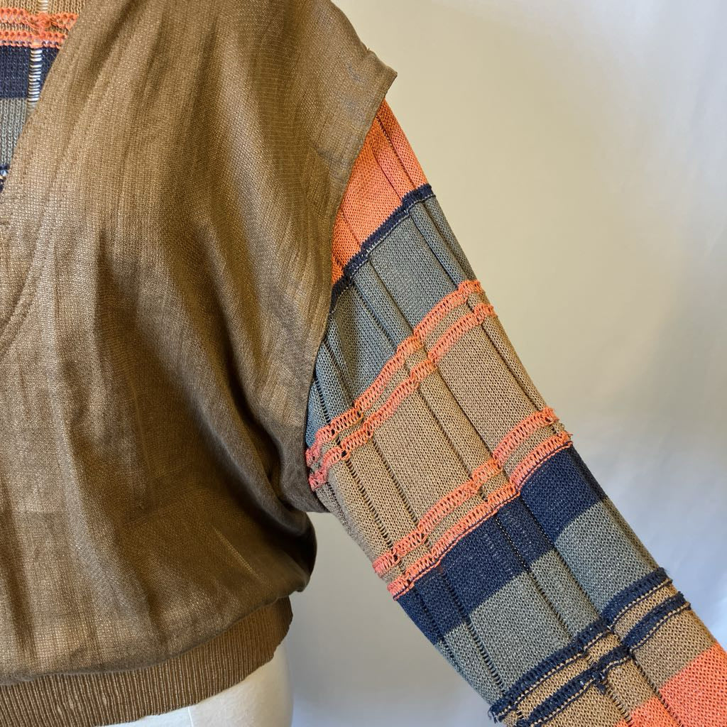 Close-up of a sweater with plaid pattern on sleeves against a white background