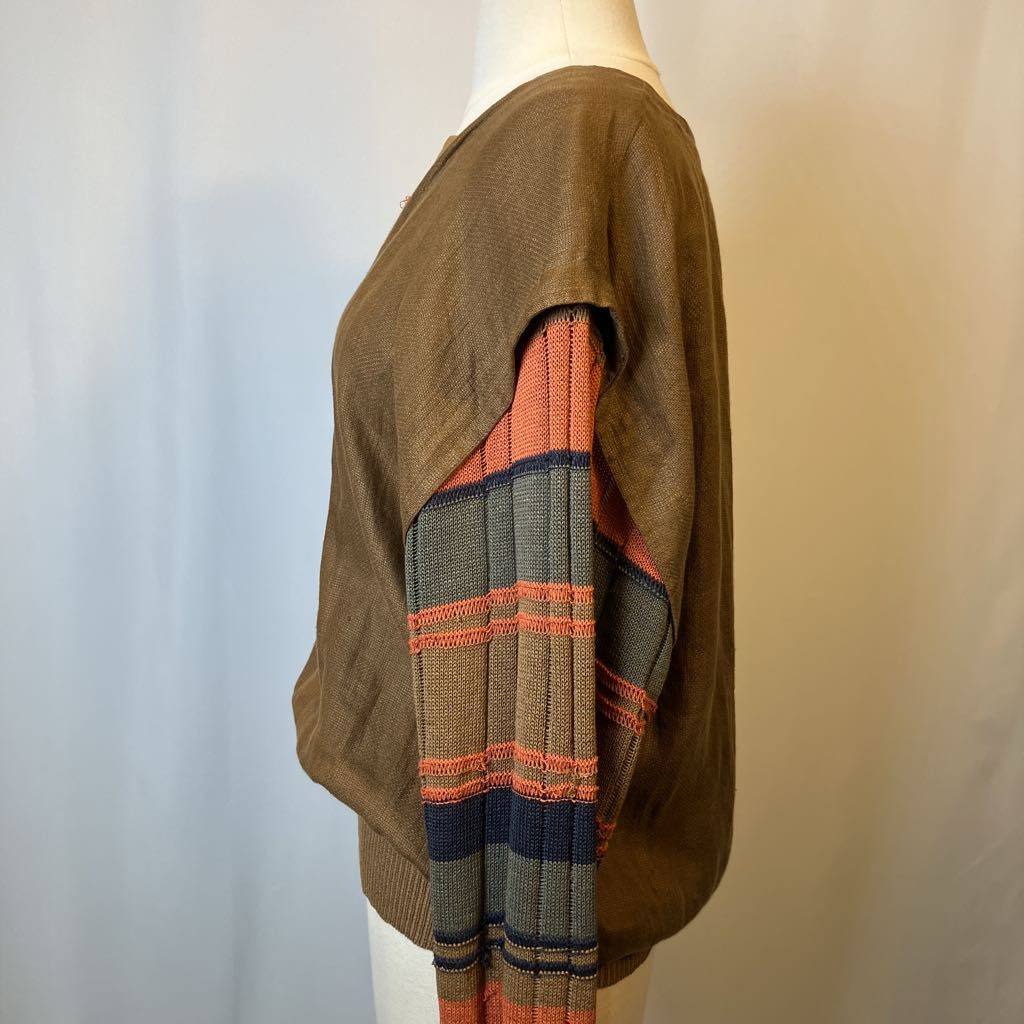 Mannequin wearing a brown sweater with a colorful striped pattern on a plain background