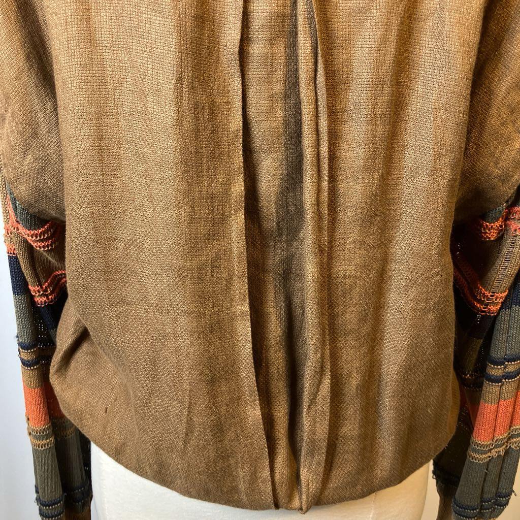 Close-up of a brown textured fabric garment with colorful patterns on sleeves.