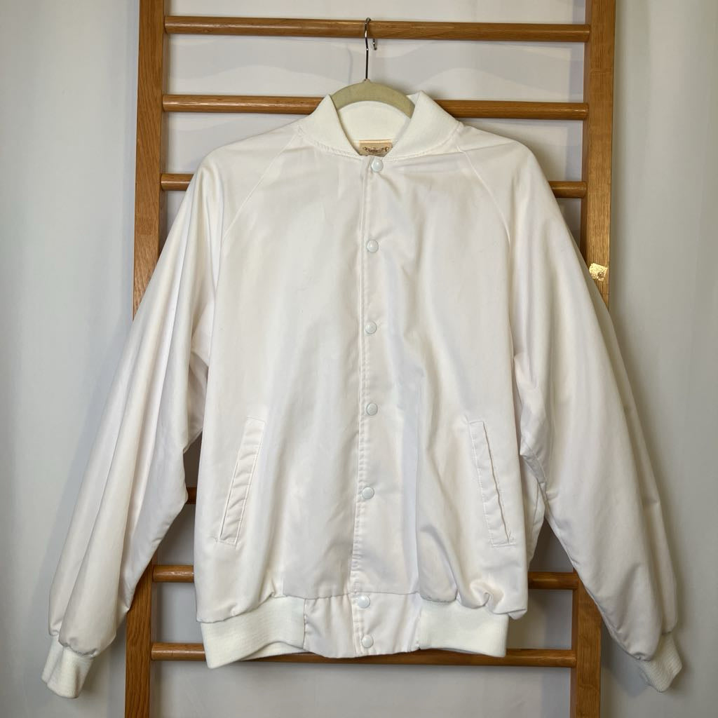 White jacket hanging on a wooden rack against a white wall