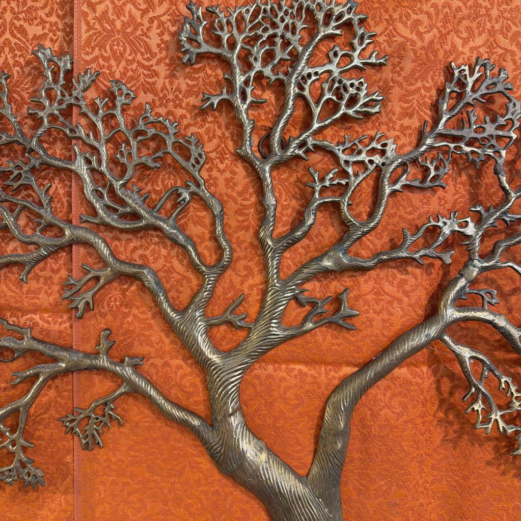 Metallic tree sculpture on an orange textured background