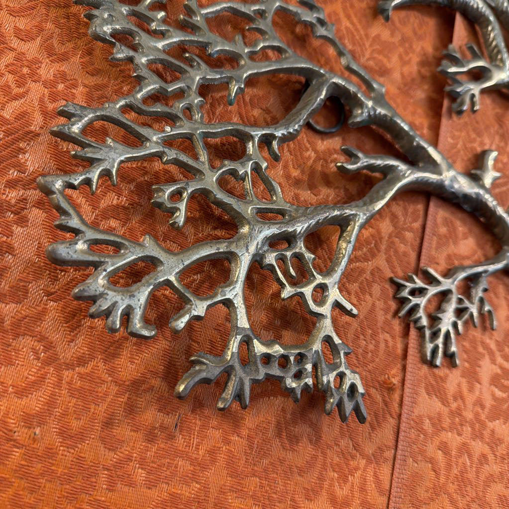 Metallic leaf-like design on a wooden surface