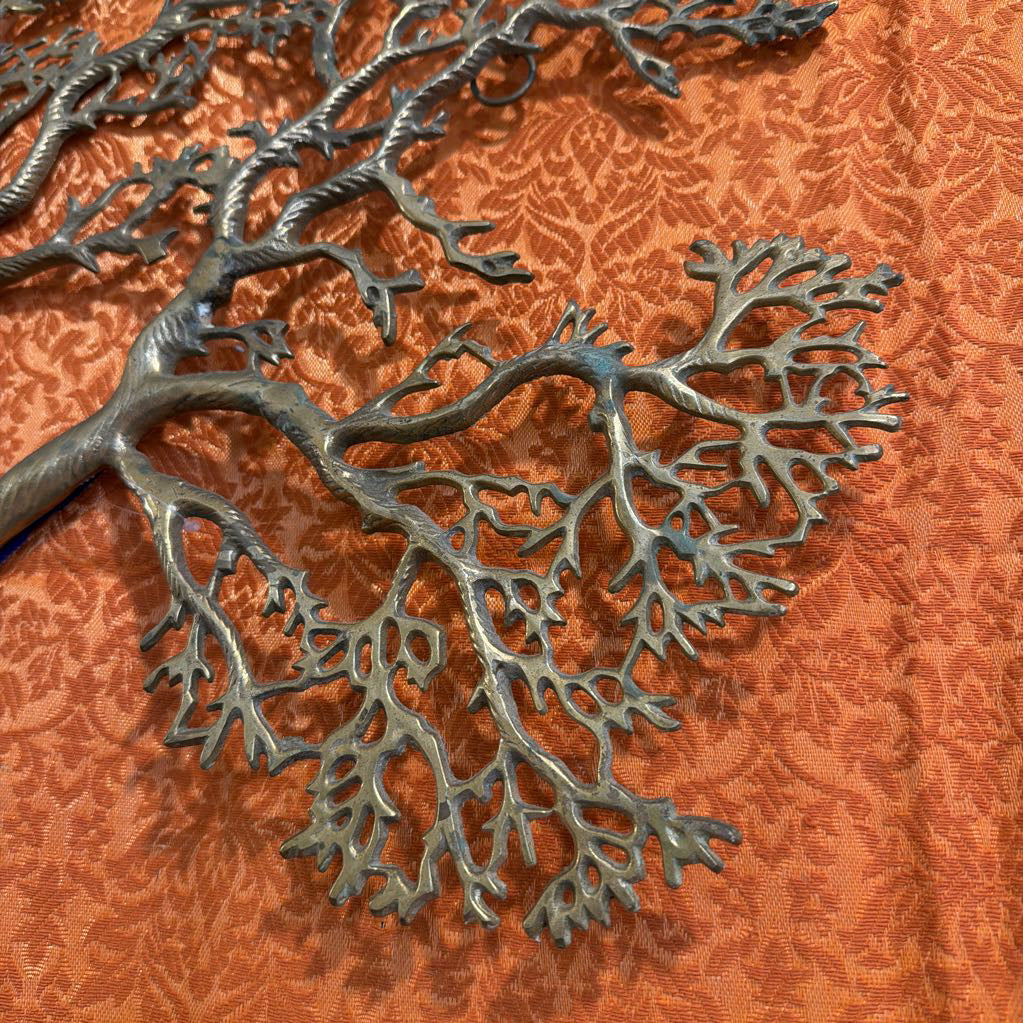 Metallic tree branch wall art on an orange textured background
