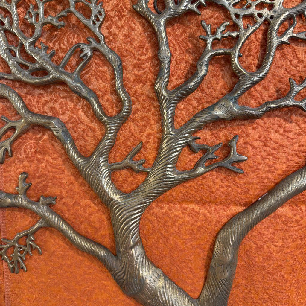 Metallic tree sculpture on an orange background