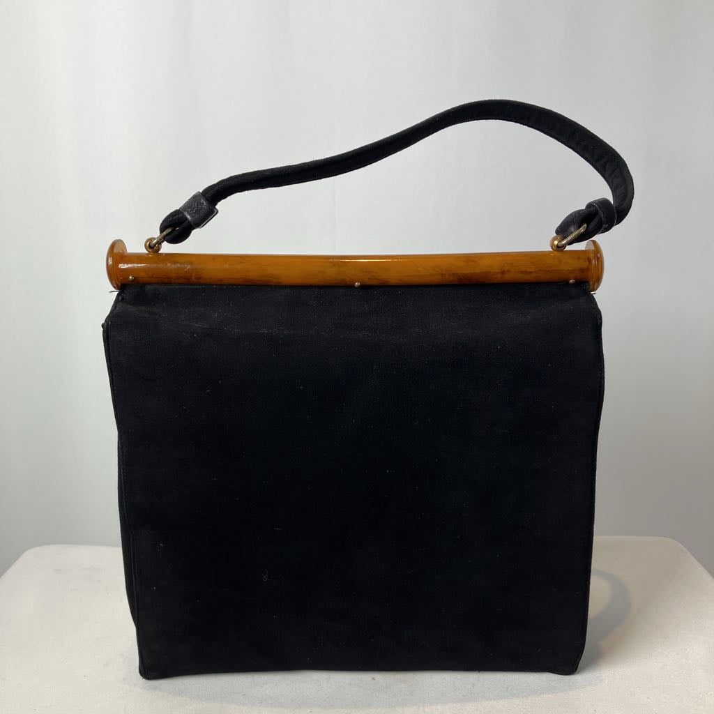 Black handbag with a lucite handle on a white background