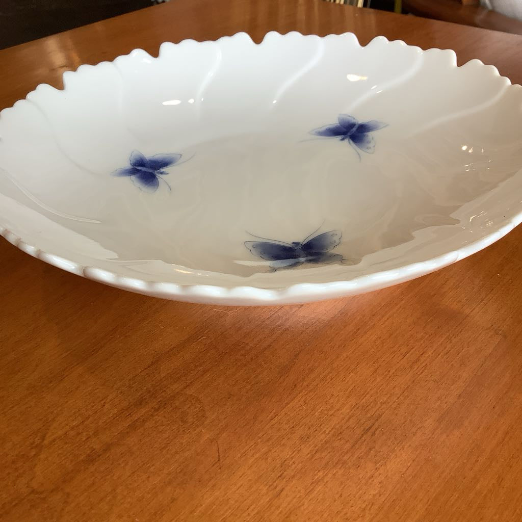 White ceramic bowl with blue butterfly designs on a wooden surface