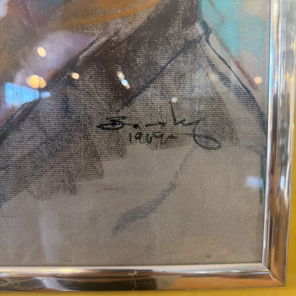 Framed artwork with a signature on a textured surface