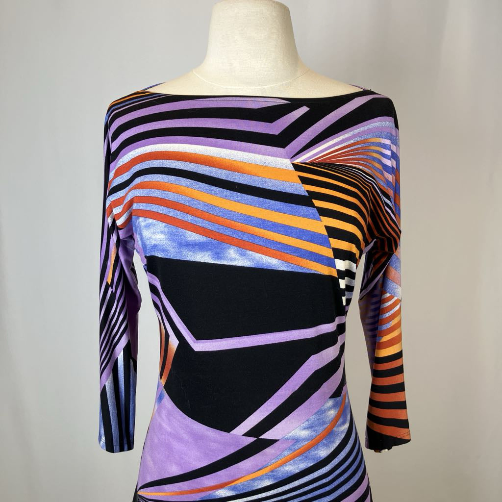 Colorful geometric-patterned dress on a mannequin against a plain background