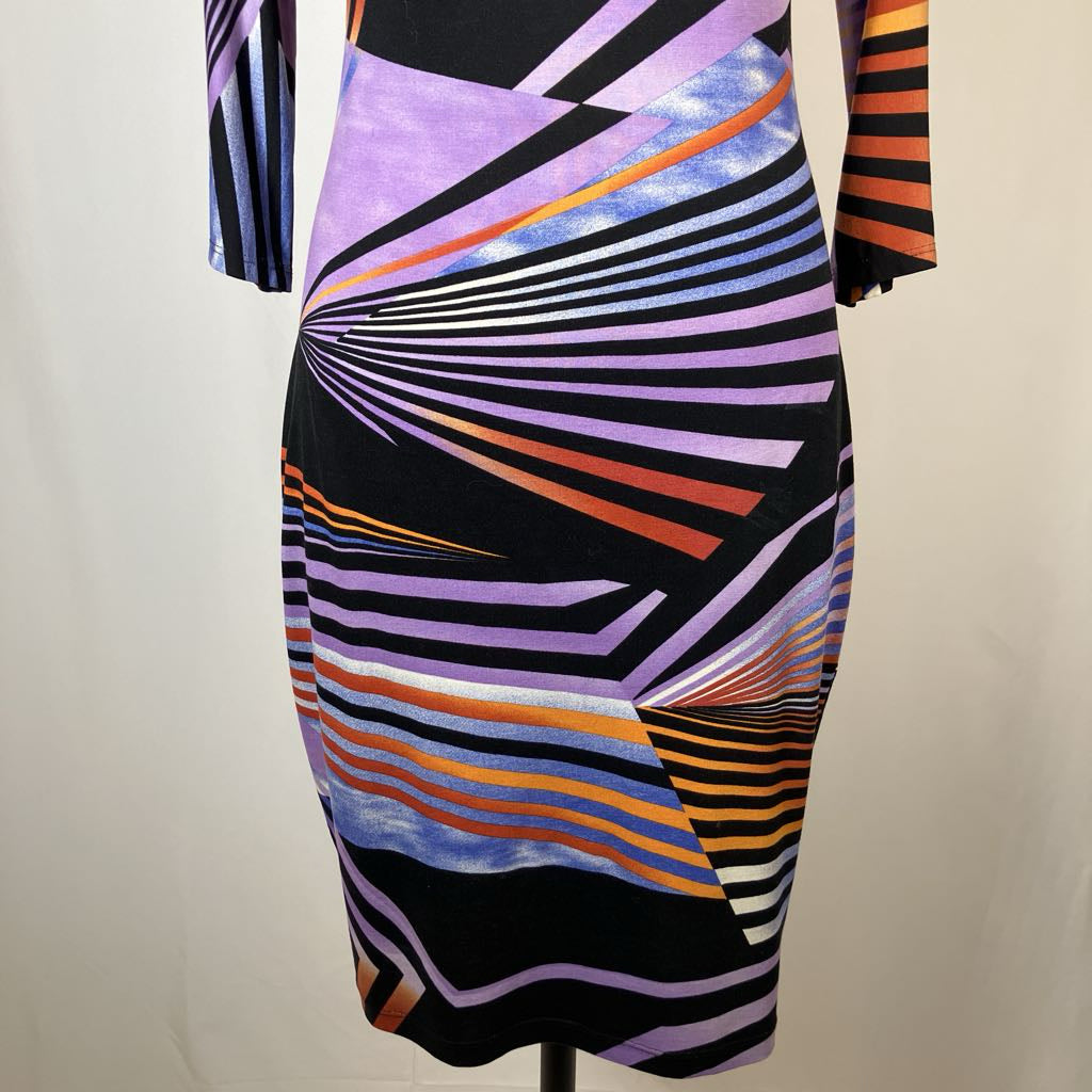 Colorful geometric-patterned dress on a mannequin against a plain background