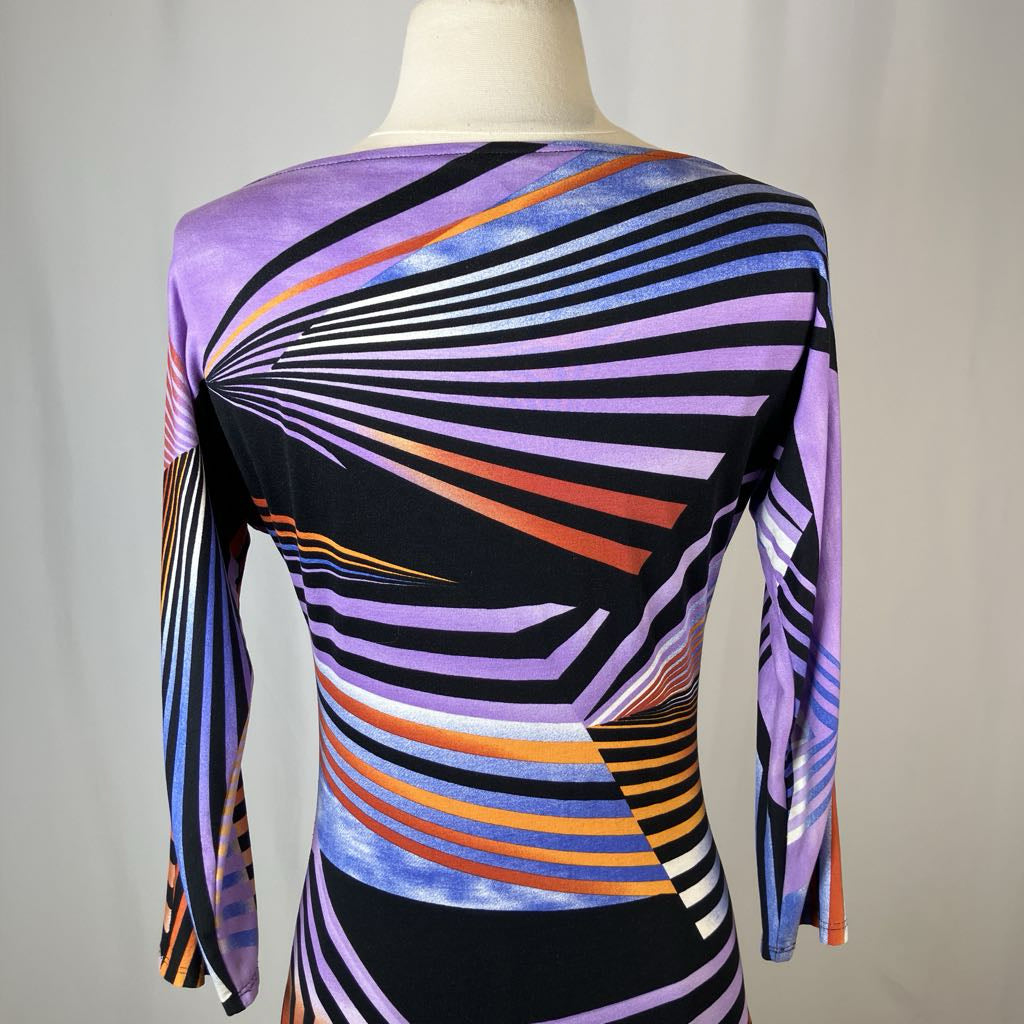 Mannequin wearing a colorful striped dress with a geometric pattern on a plain background