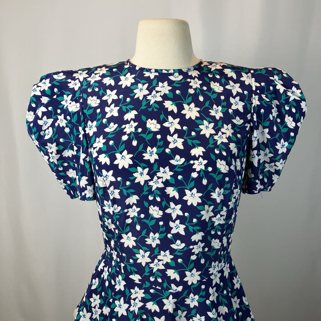 Navy blue dress with white floral pattern on a mannequin against a plain background