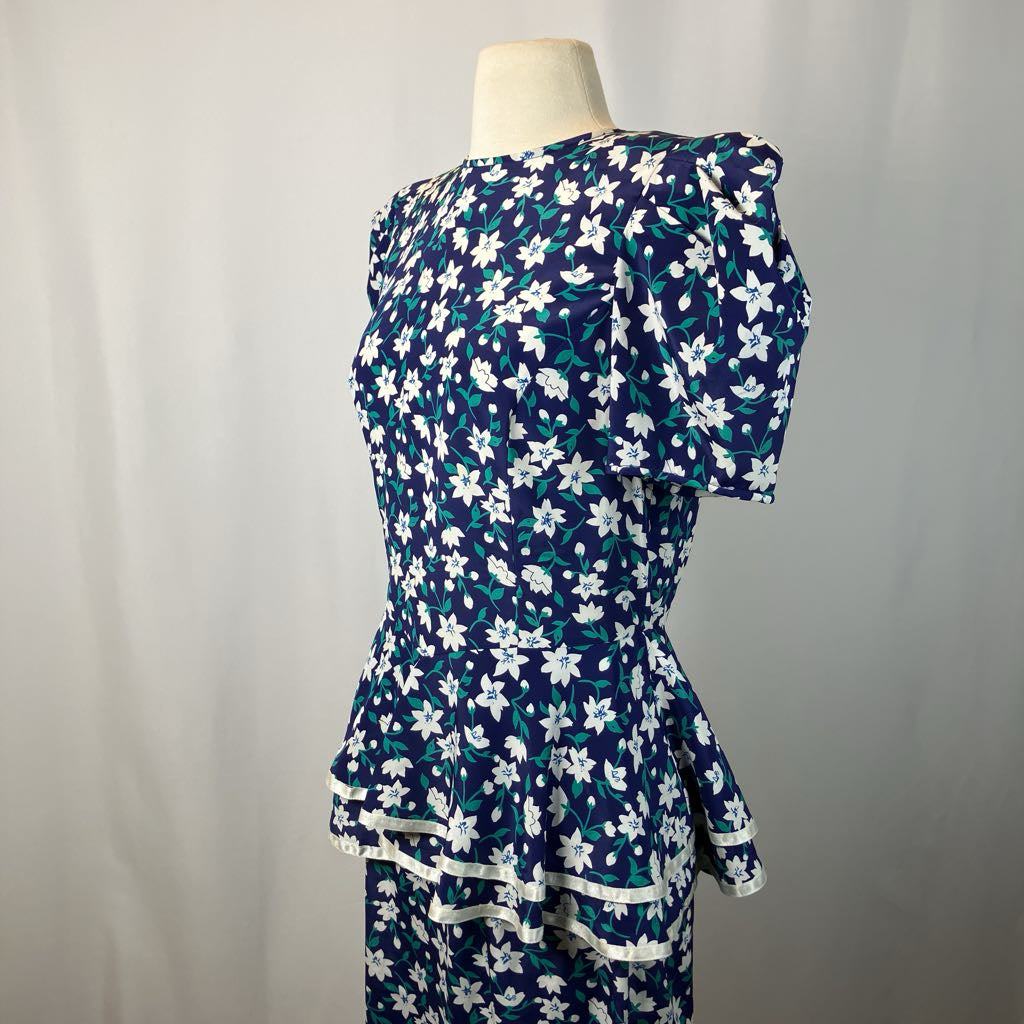 Navy blue dress with white floral pattern on a mannequin against a plain background