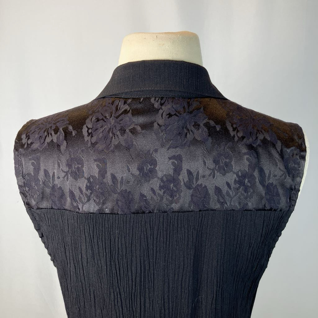 Black vest on a mannequin against a gray background