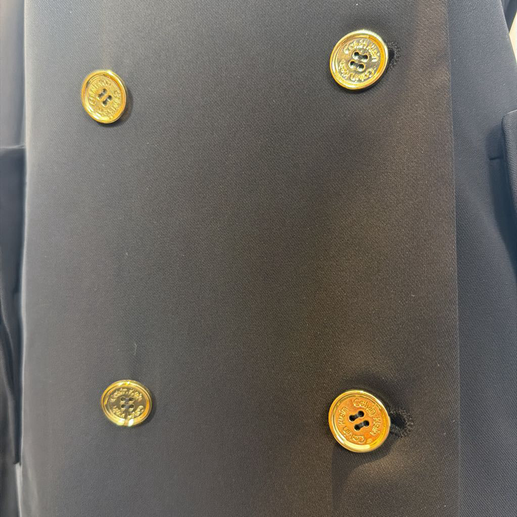 Close-up of a dark coat dress with gold buttons