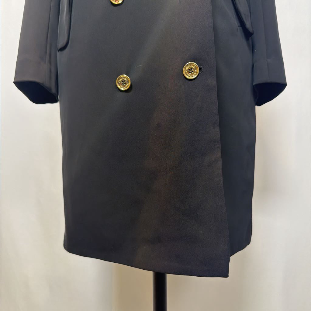 Black coat dress with gold buttons on a mannequin against a white background