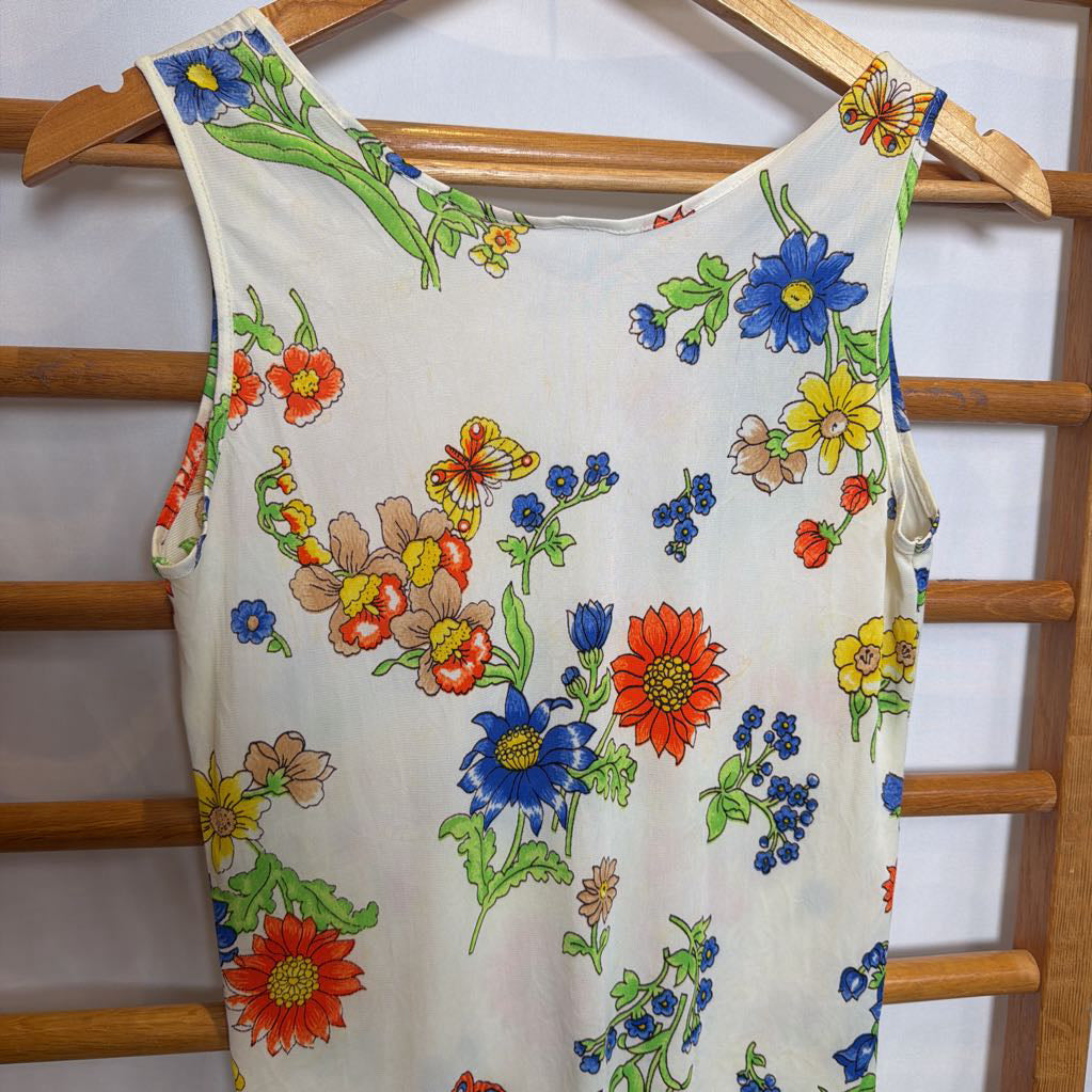 Floral-patterned dress on a wooden hanger against a white background