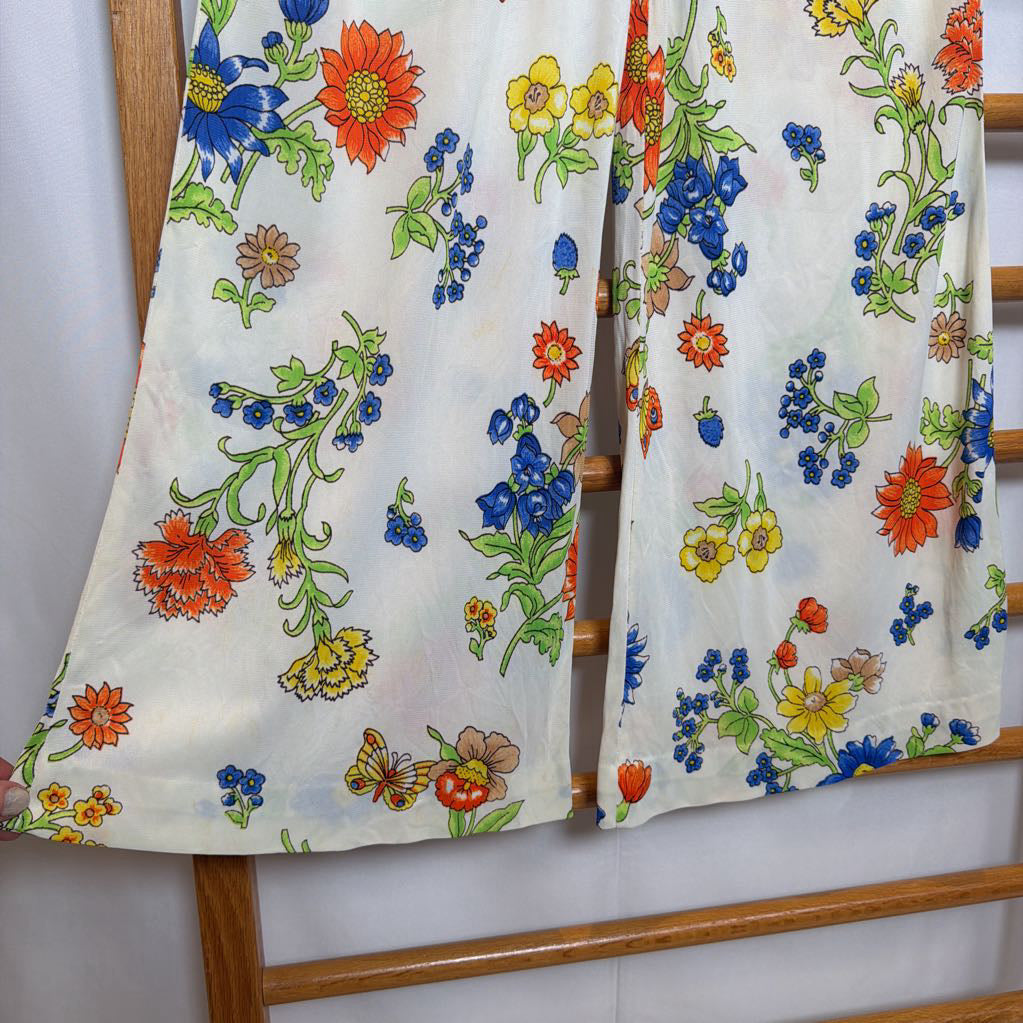 Floral-patterned fabric draped over a wooden rack against a white wall.