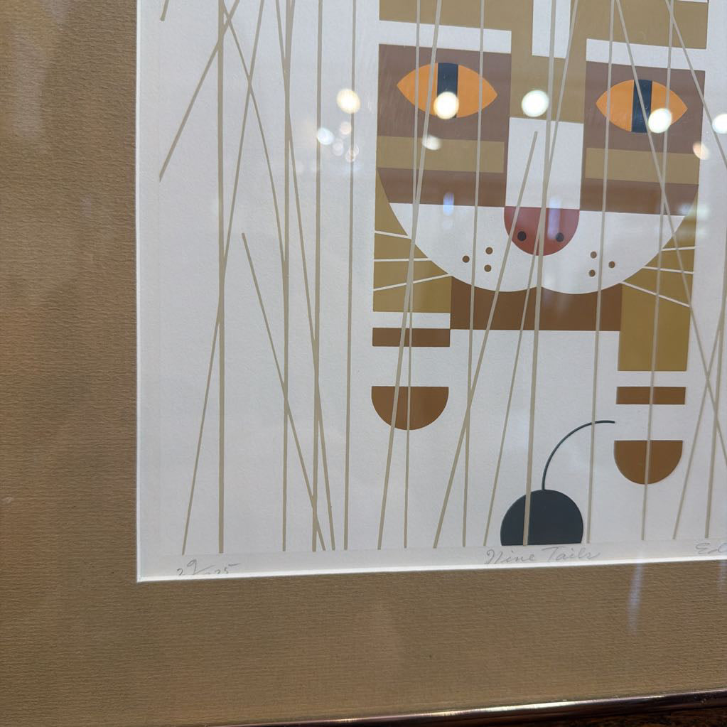 Abstract art print of a cat's face with geometric shapes on a white background, framed in gold.