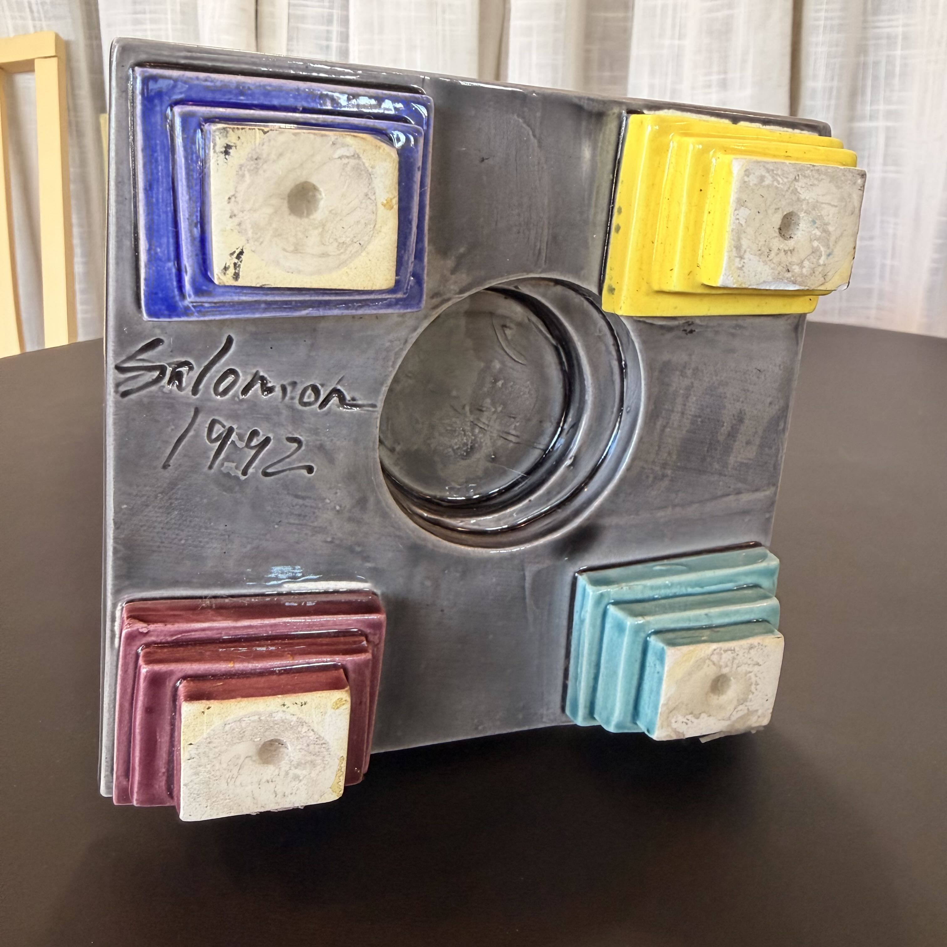 Vintage piece with colorful components with signature on a dark surface