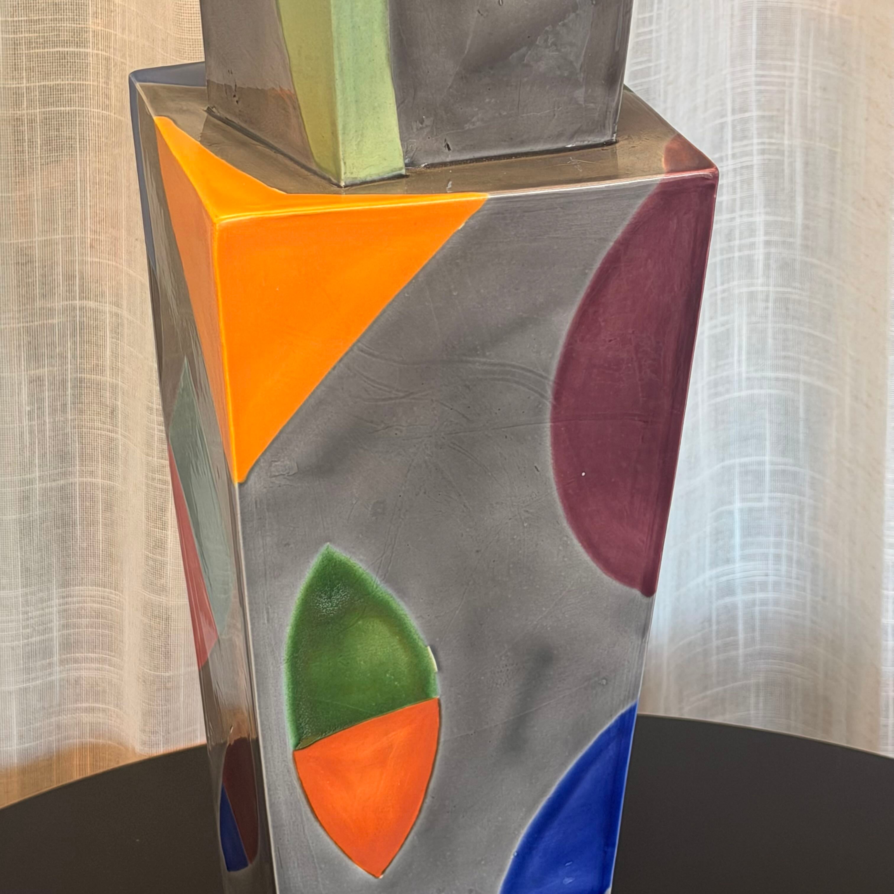 Abstract art piece with geometric shapes in front of a curtain