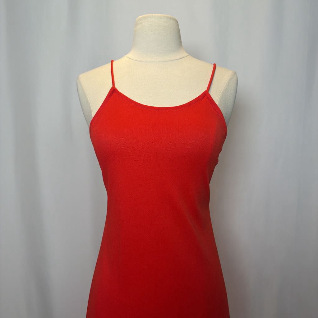 Red dress on a mannequin against a plain background