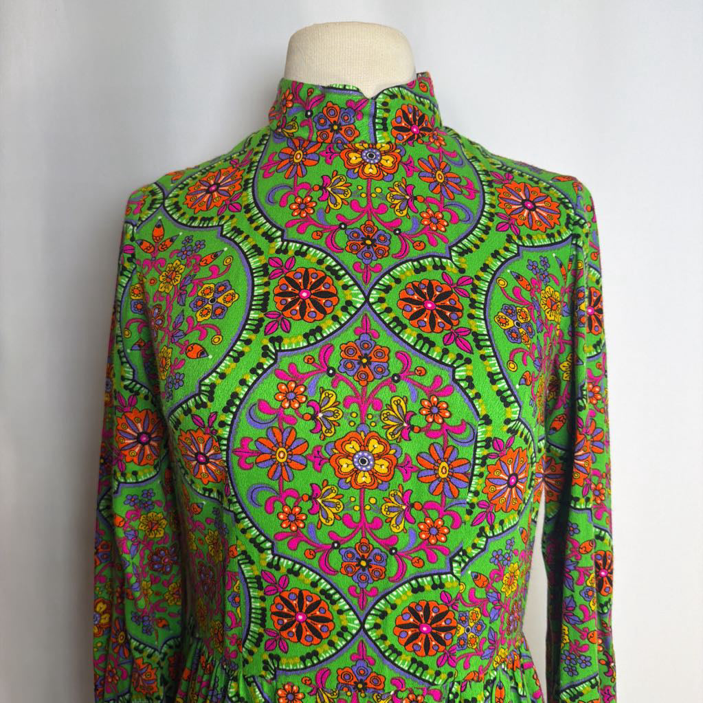 Colorful patterned dress on a mannequin against a plain background