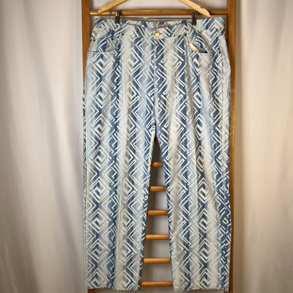 Blue and white patterned pants hanging on a wooden hanger against a plain background
