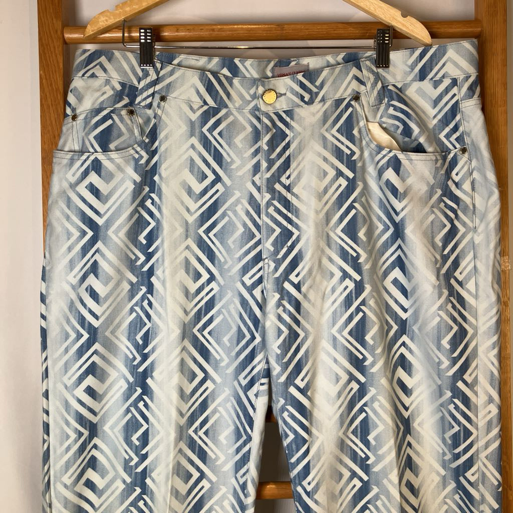 Blue and white patterned pants hanging on a wooden hanger.