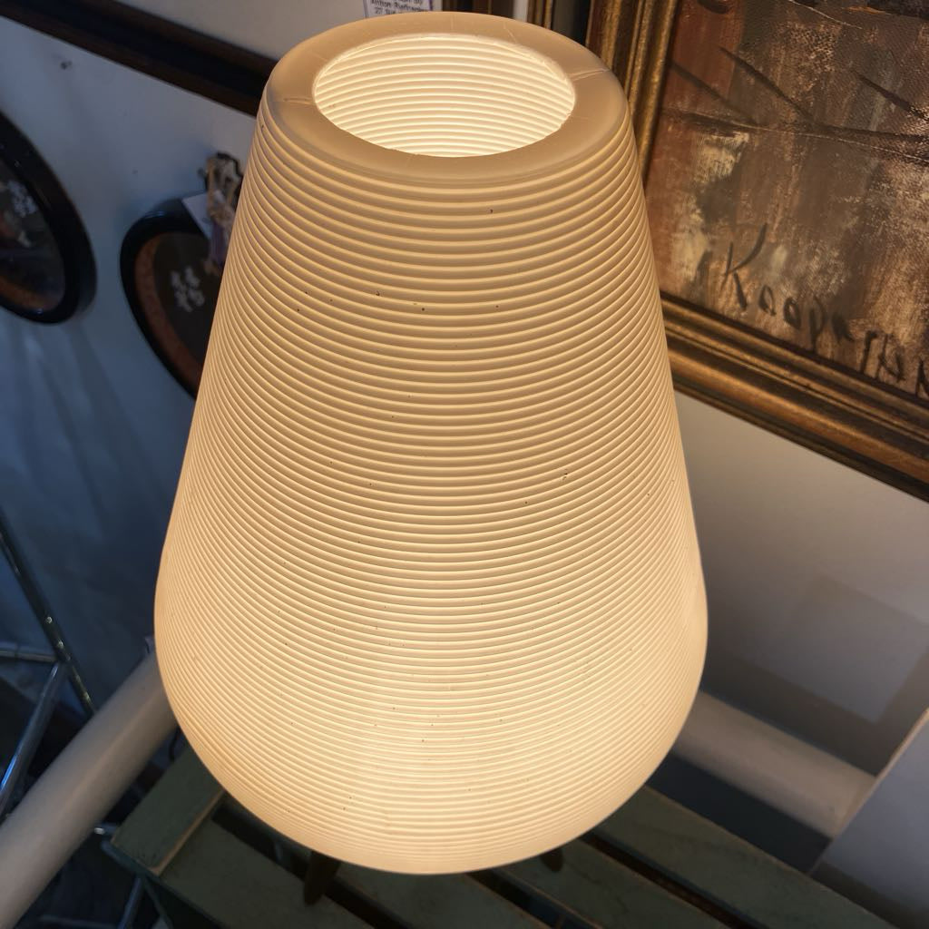 Textured beige lamp on a surface with a blurred background