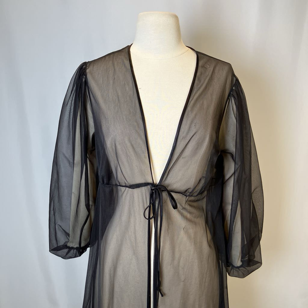 Black sheer robe on a mannequin against a plain background
