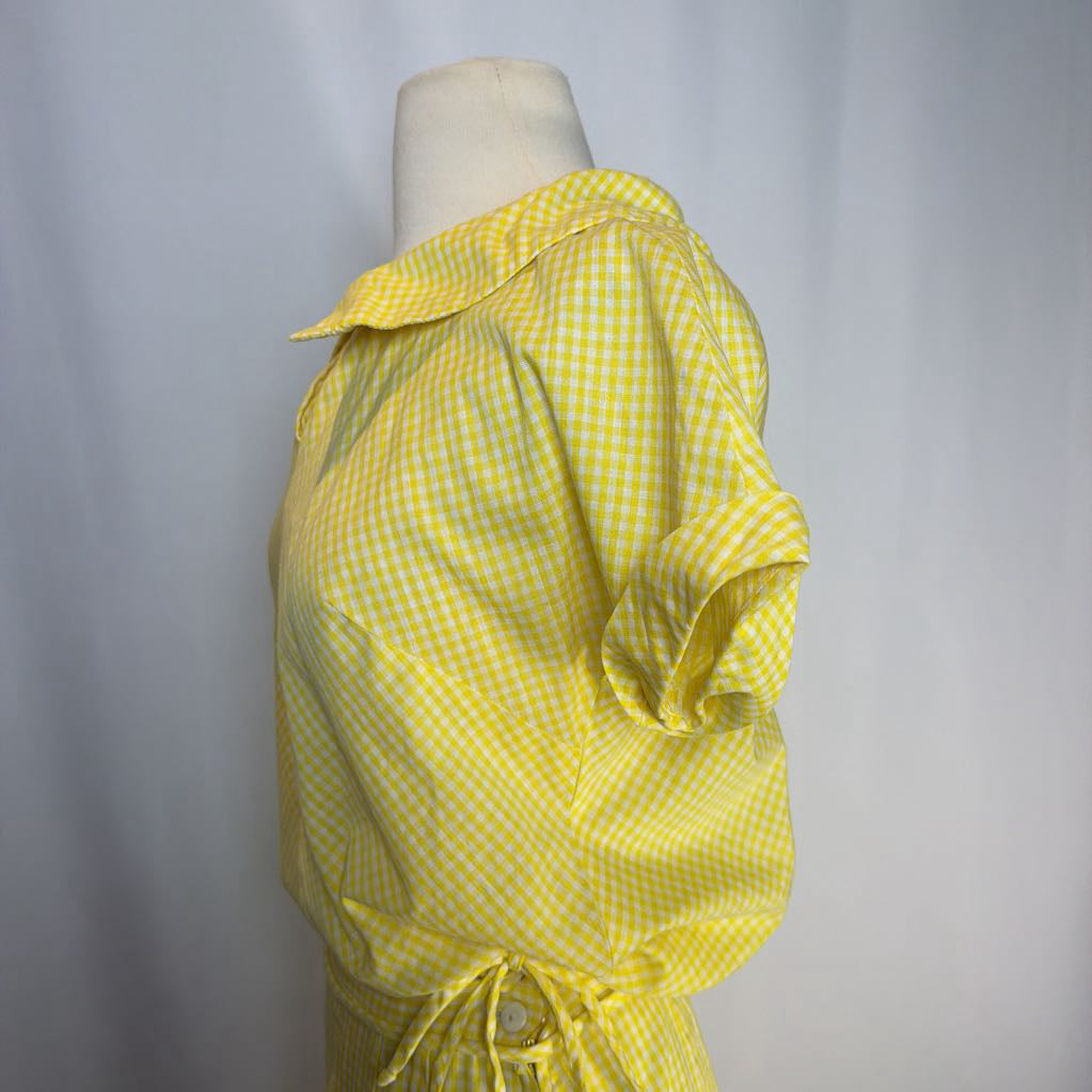Yellow checkered dress on a mannequin against a plain background