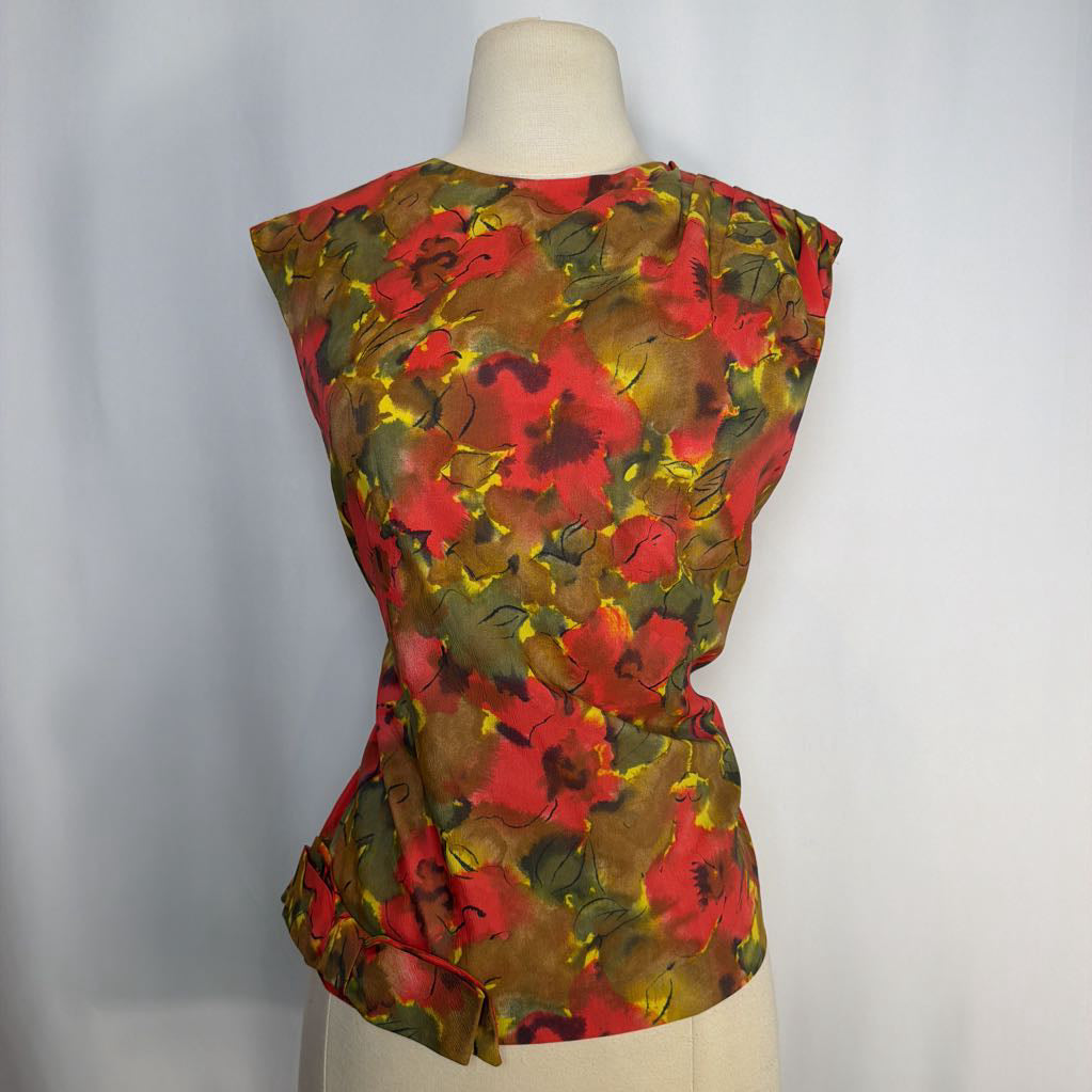 Colorful floral sleeveless top on a mannequin against a plain background