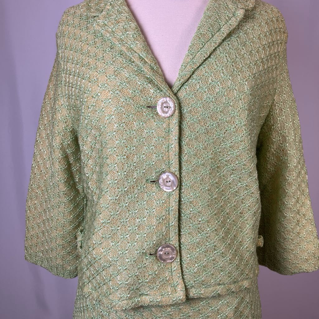 Green textured blazer with three buttons on a purple background