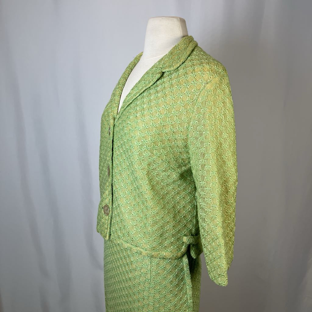 Green patterned suit on a mannequin against a plain background