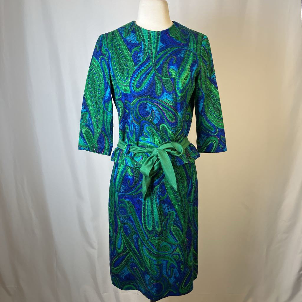 Green and blue patterned dress on a mannequin against a plain background