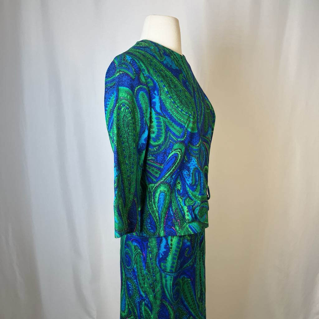 Mannequin wearing a green and blue patterned outfit against a plain background