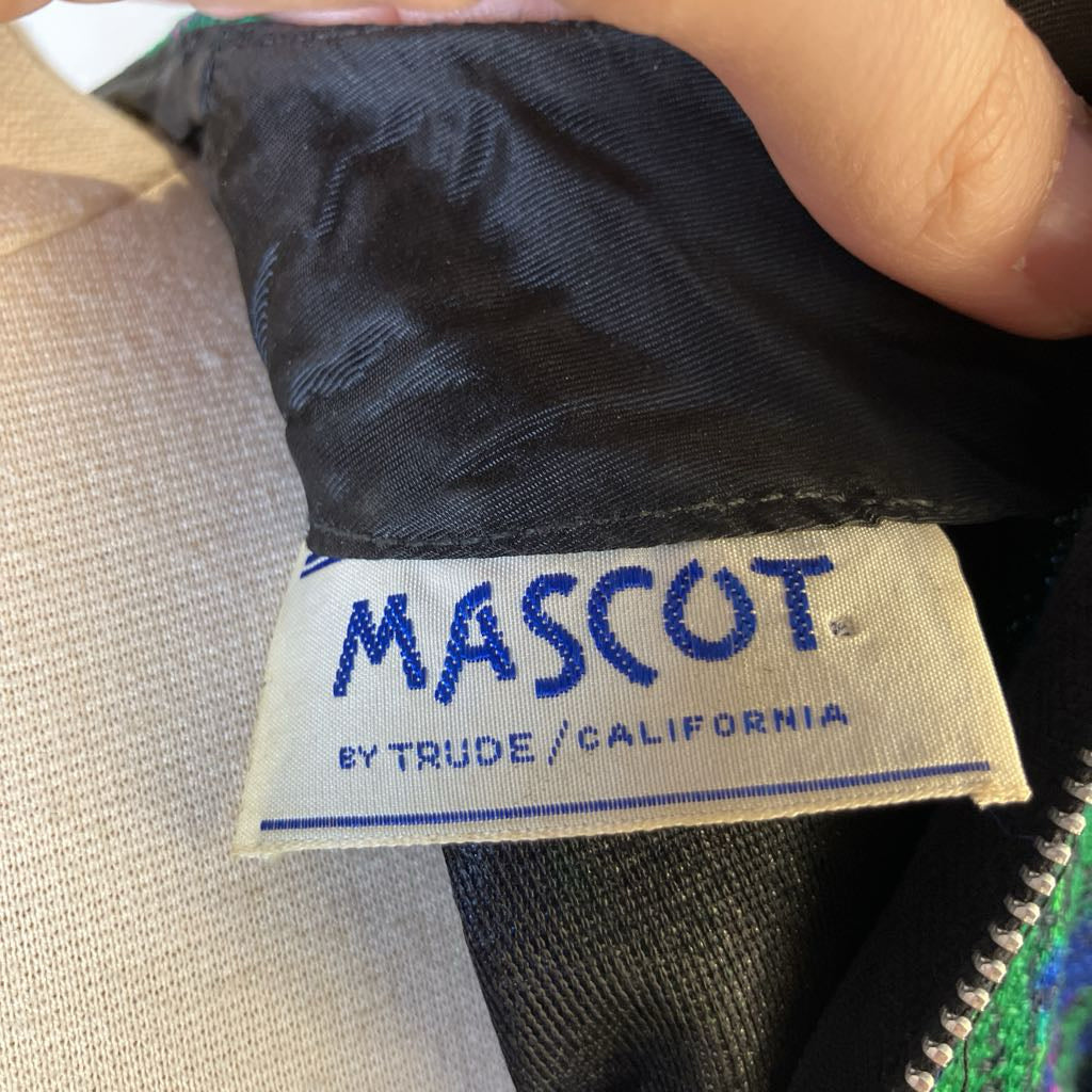 Close-up of a 'MASCOT' label on a garment with visible text.