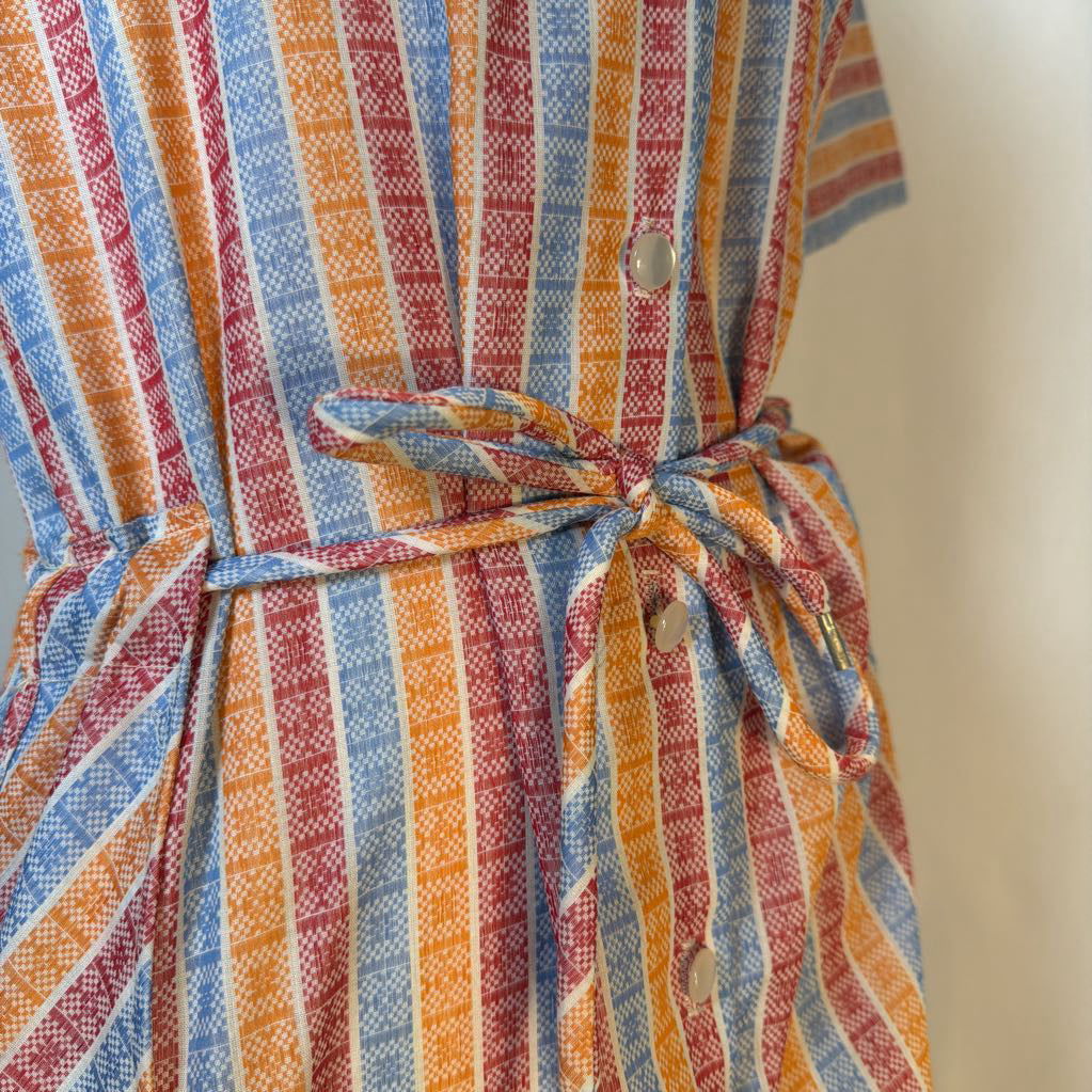 Close-up of a colorful striped dress with a tie waist.