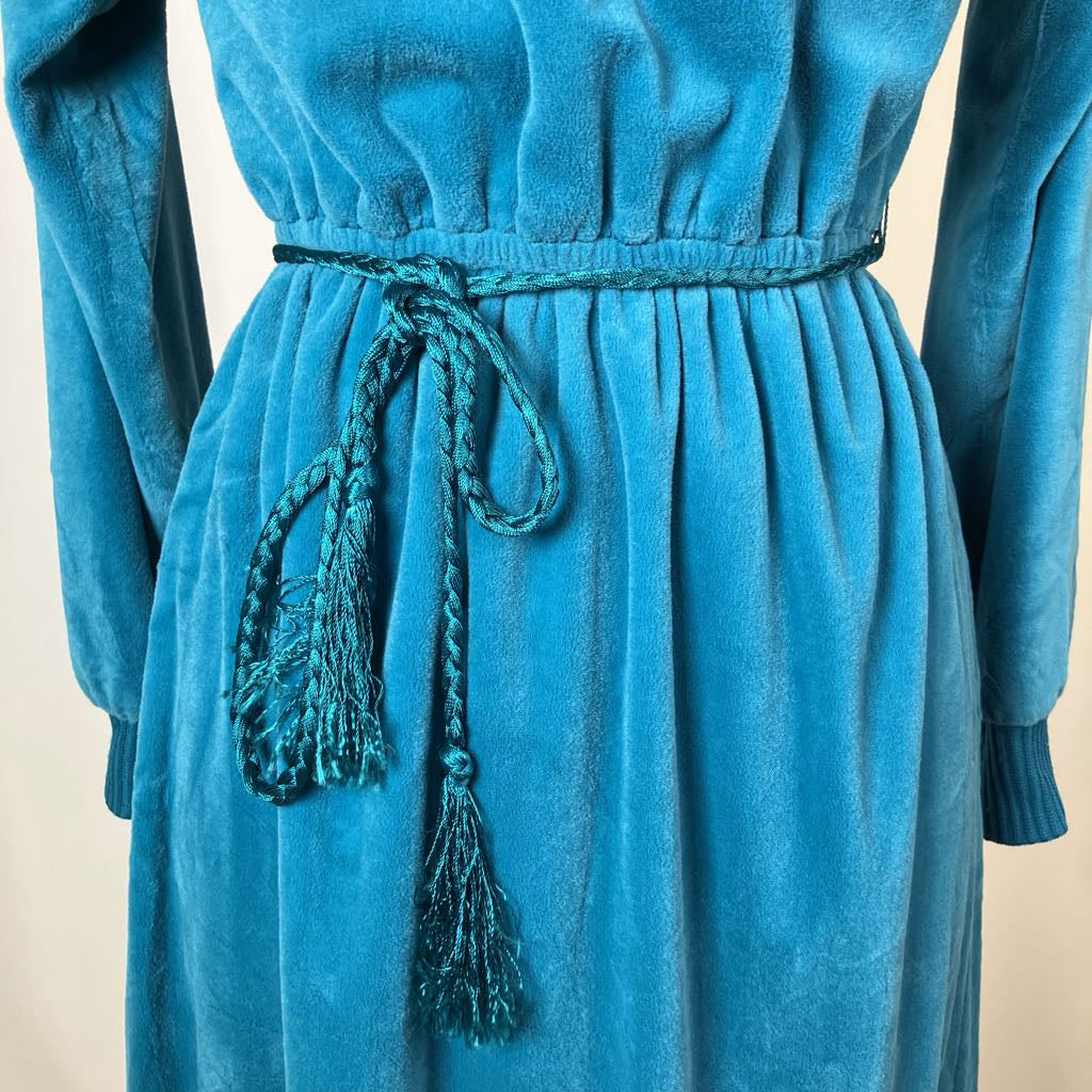 Blue dress with a belt and tassels on a beige background