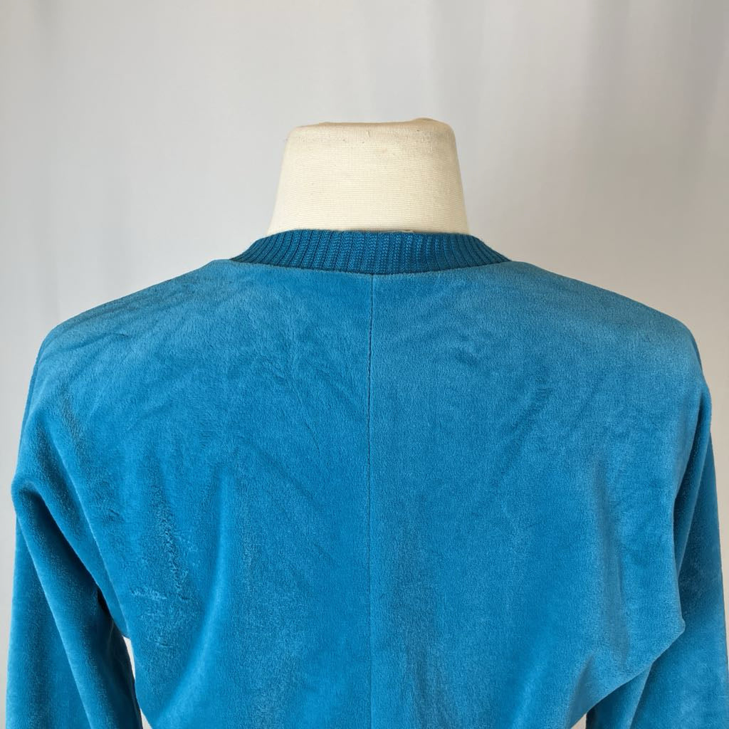 Blue sweater on a mannequin against a plain background