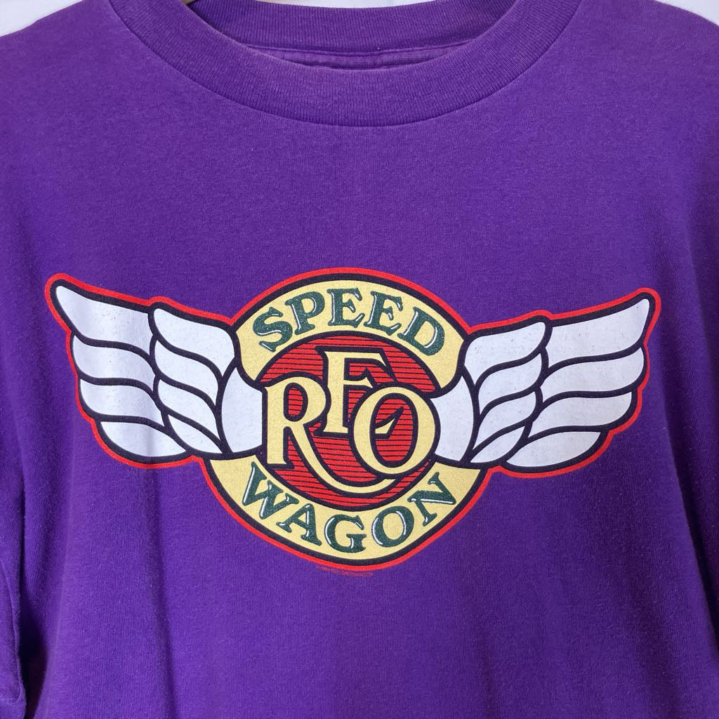 Purple shirt with a colorful logo featuring wings and text on a plain background
