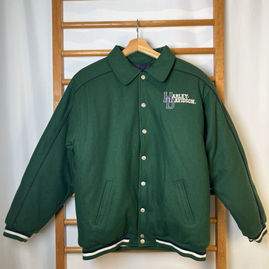 Green Harley Davidson jacket on a wooden rack against a white wall