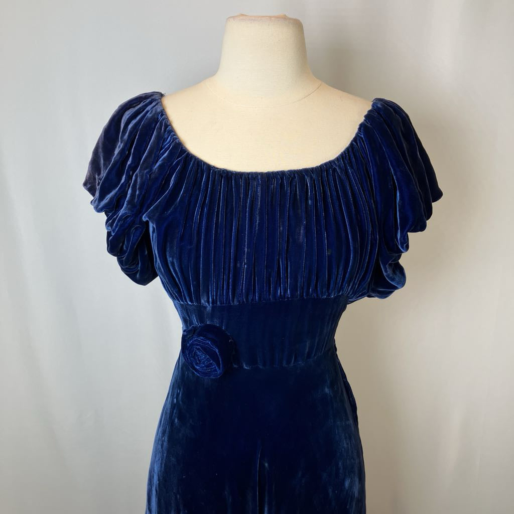 Navy blue velvet dress on a mannequin against a plain background