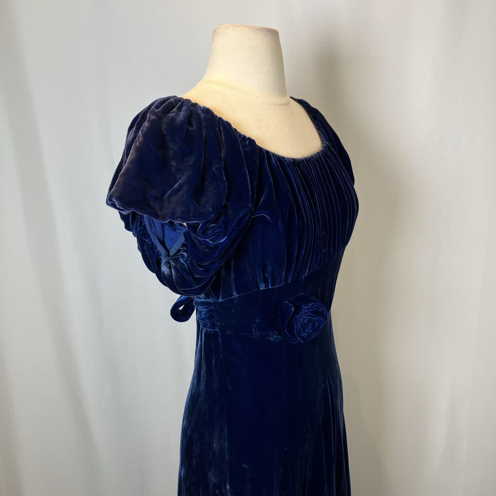 Navy velvet dress on a mannequin against a plain background