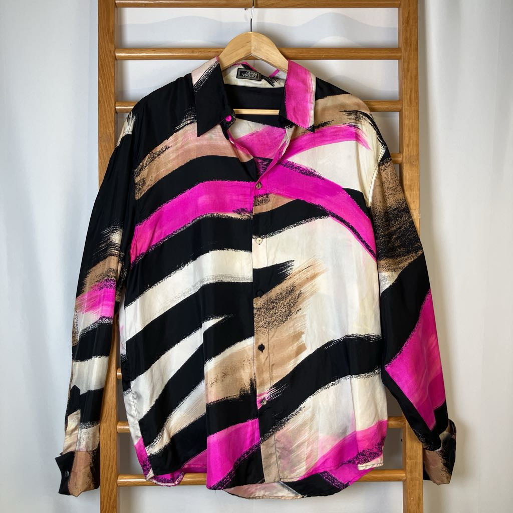 Colorful striped shirt on a wooden hanger against a white background