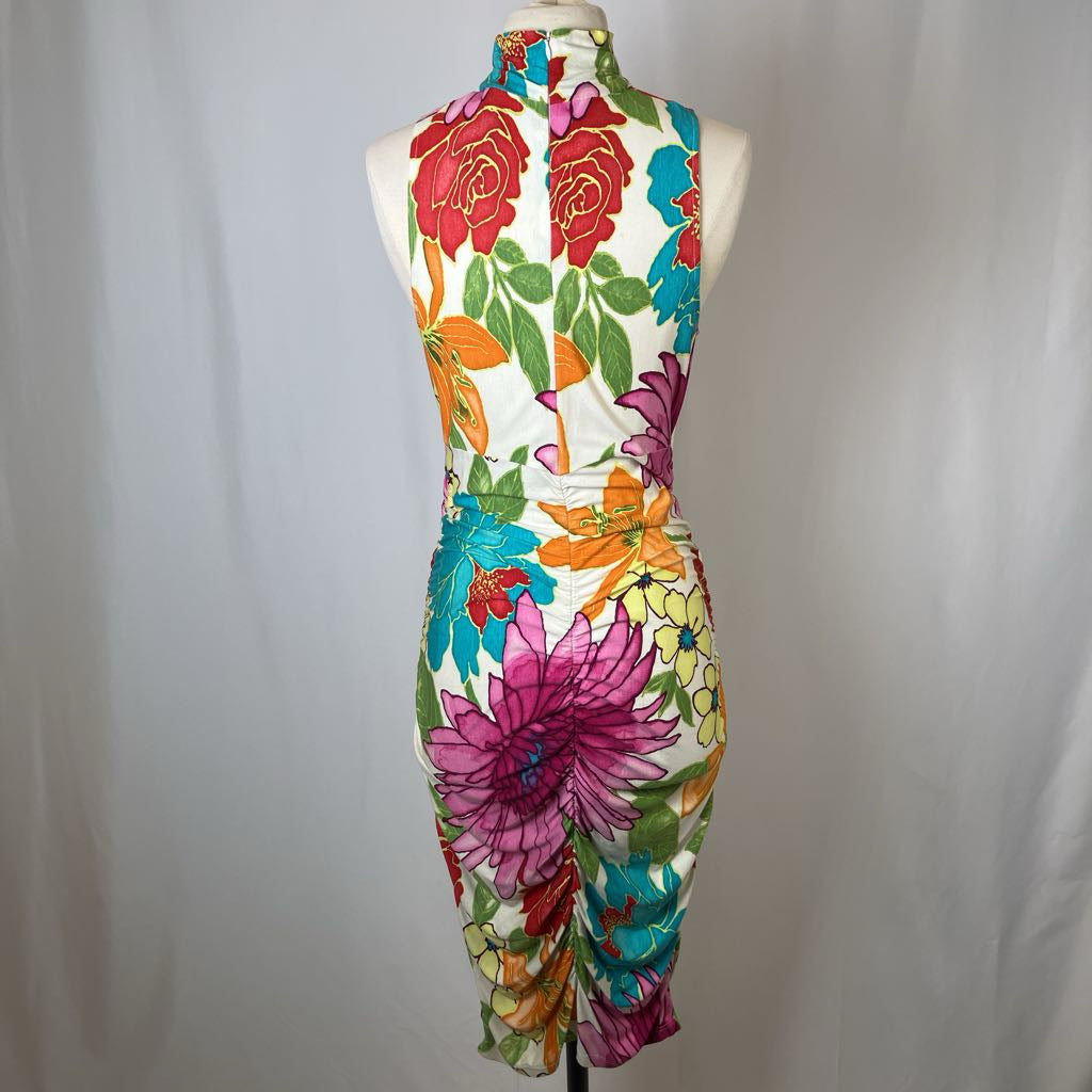 Colorful floral dress on a mannequin against a plain background