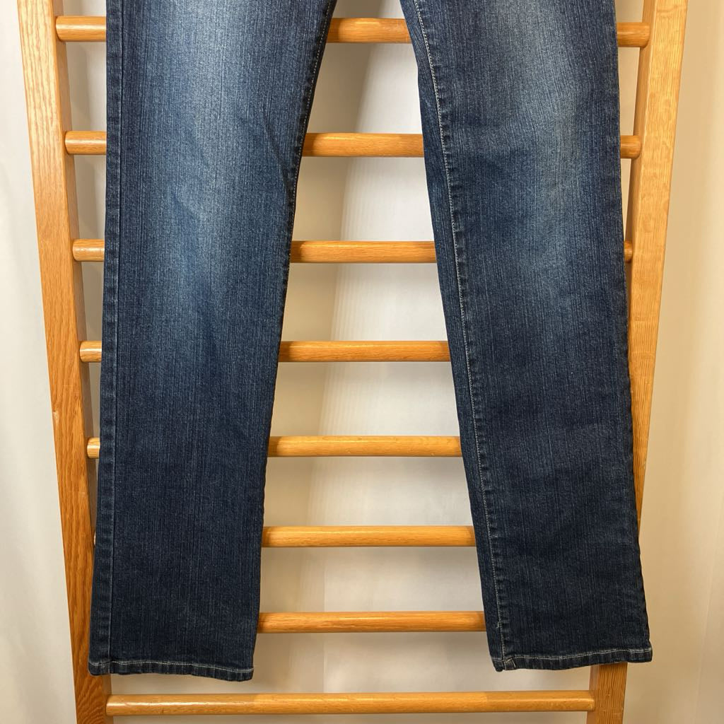 Pair of blue jeans hanging on a wooden rack against a plain background