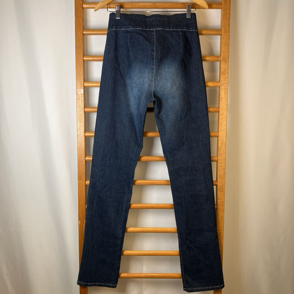 Blue jeans hanging on a wooden rack against a plain background